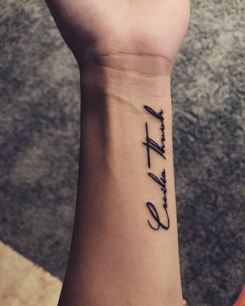 bold line script wrist tattoo