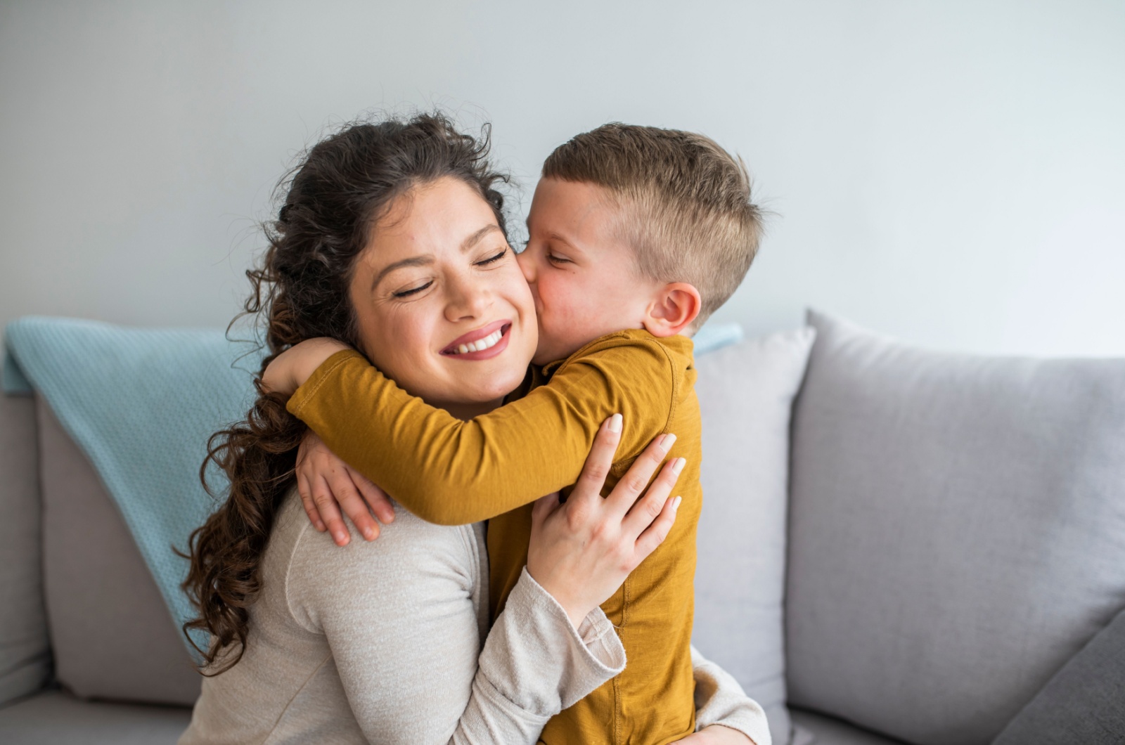 boy kissing mom on the cheek