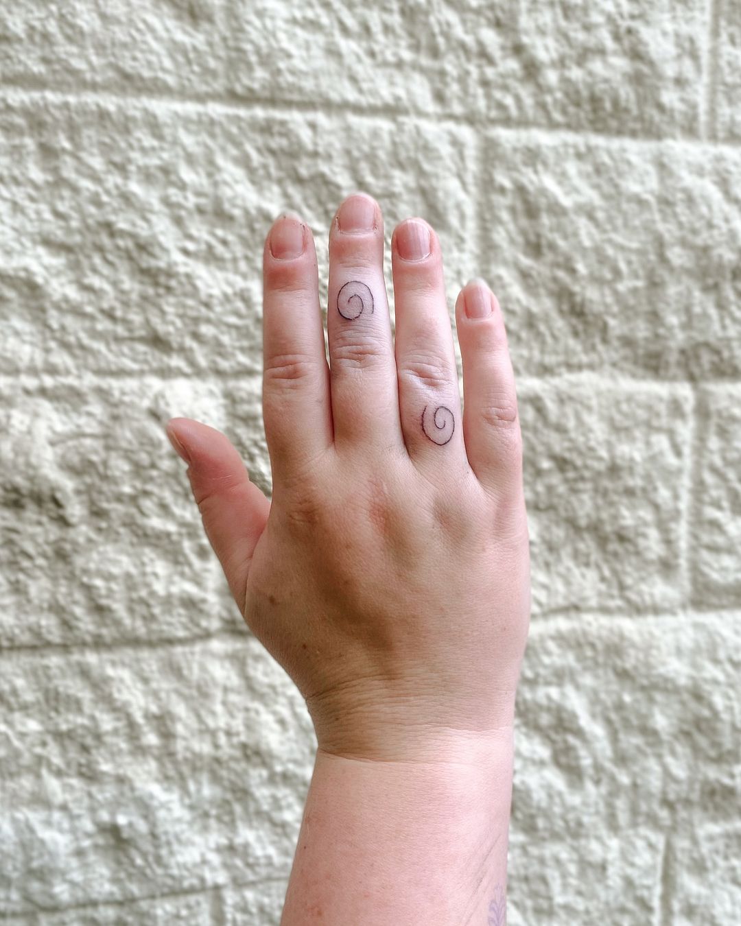 simpatica coppia di tatuaggi a spirale sulle dita