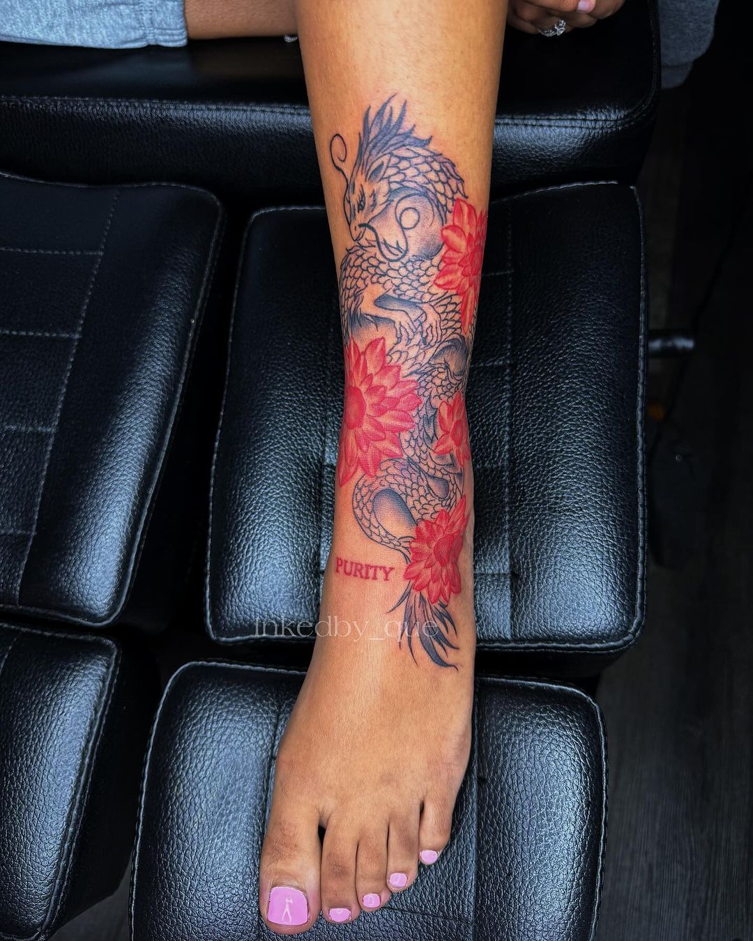 tatuaje de dragón con flores rojas en la pierna