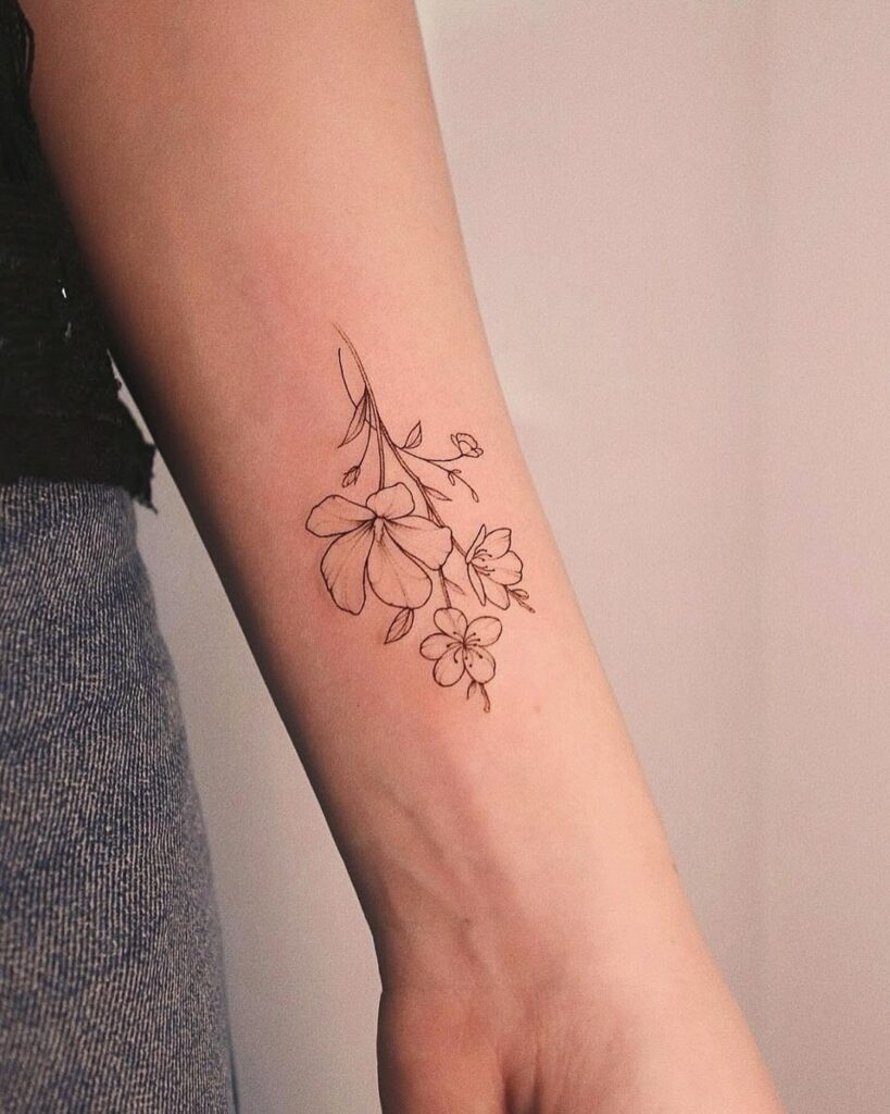 tatuaje en la muñeca de una flor de cerezo de líneas finas