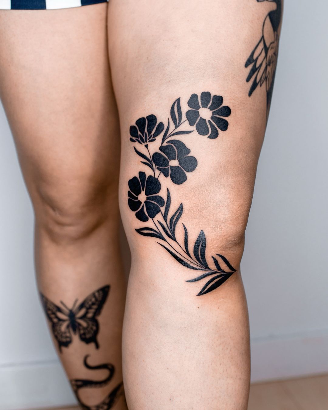 tatuagem de flores à volta do joelho