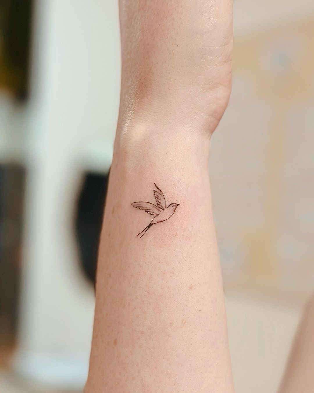 mini tatuaggio a forma di uccello