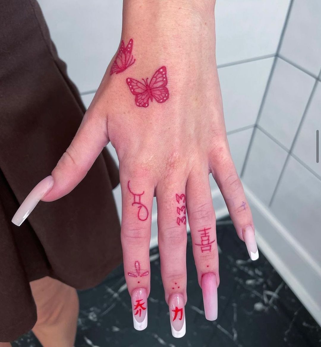 tatuaggio a mano con dita rosse