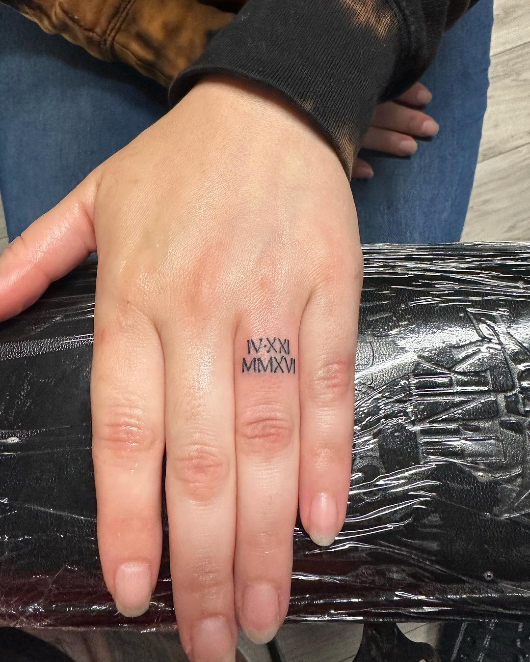 tatuaje de números romanos en el dedo
