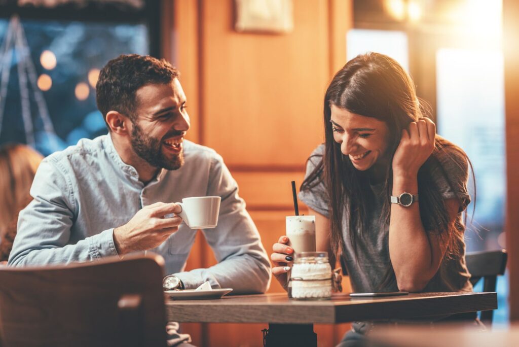 smiling loving couple laughing over coffee