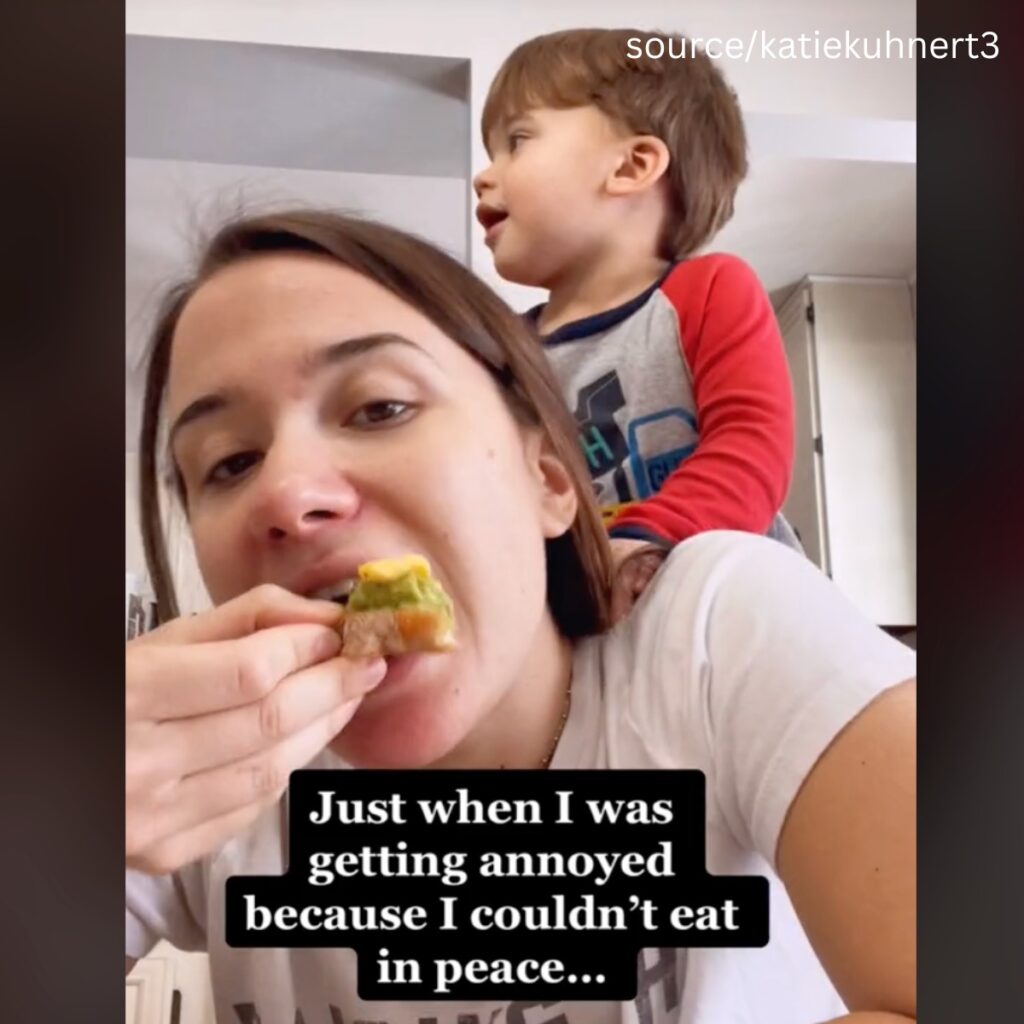 se graba a la mujer comiendo y hablando con el niño a la espalda