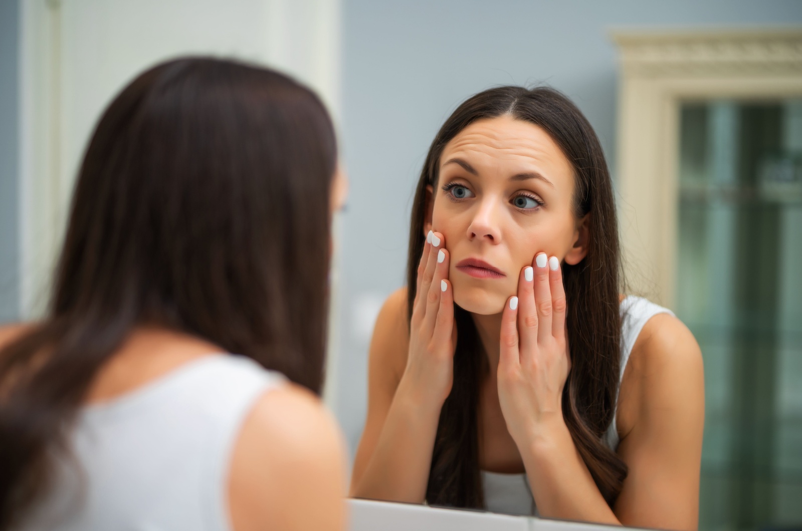 tired woman looking in the mirror