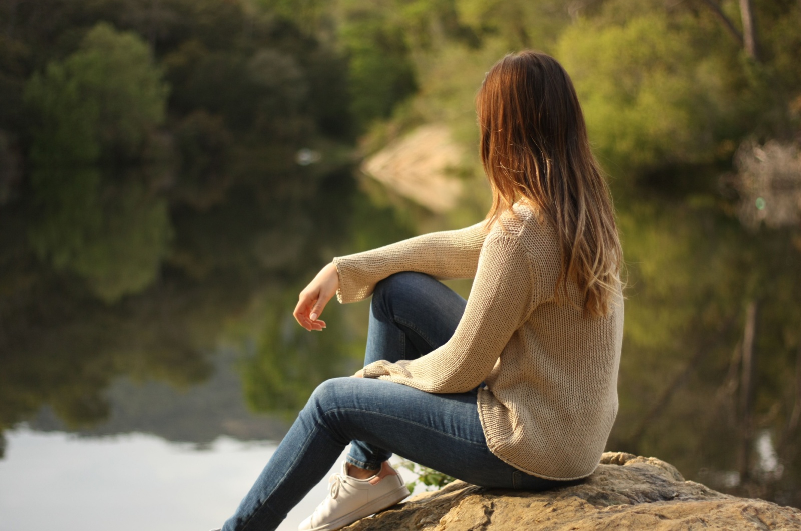 mulher sentada junto ao lago