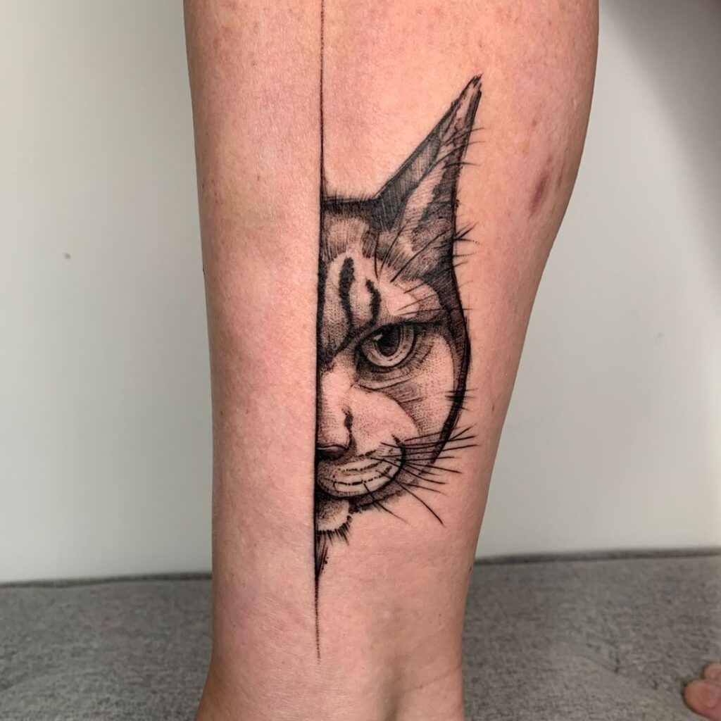 Tatuaggio della gamba con gatto che fa capolino