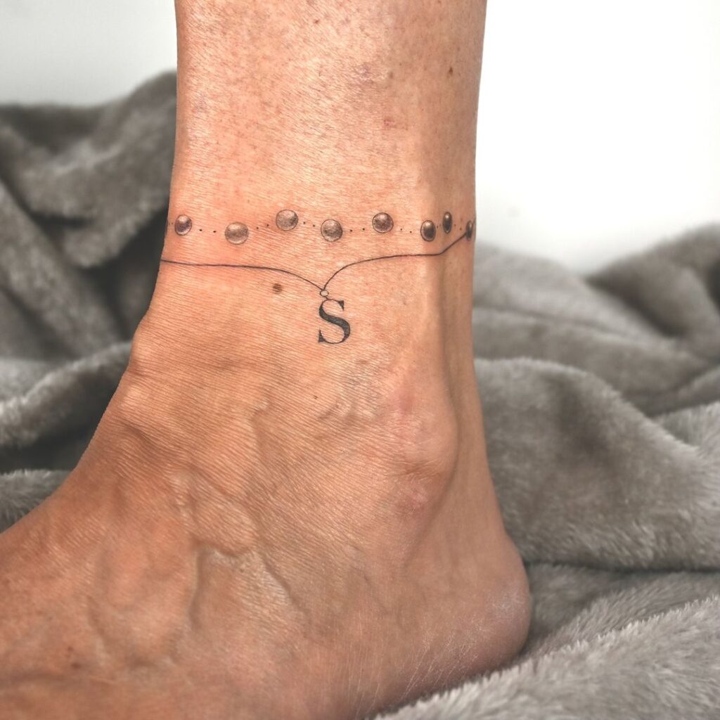 Tatuaje de tobillera con inicial