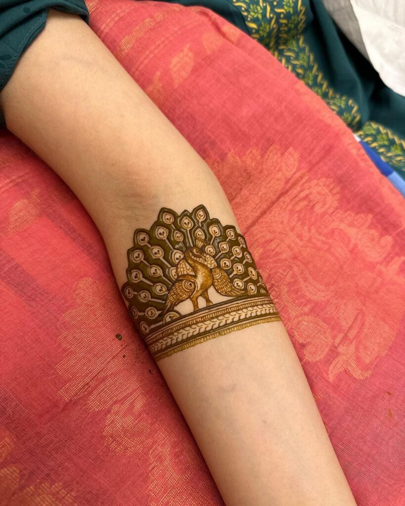 Diseño de henna de pavo real en el antebrazo