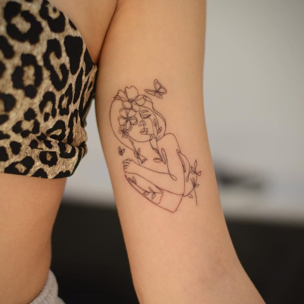 Tatuagem de retrato feminino com elementos botânicos