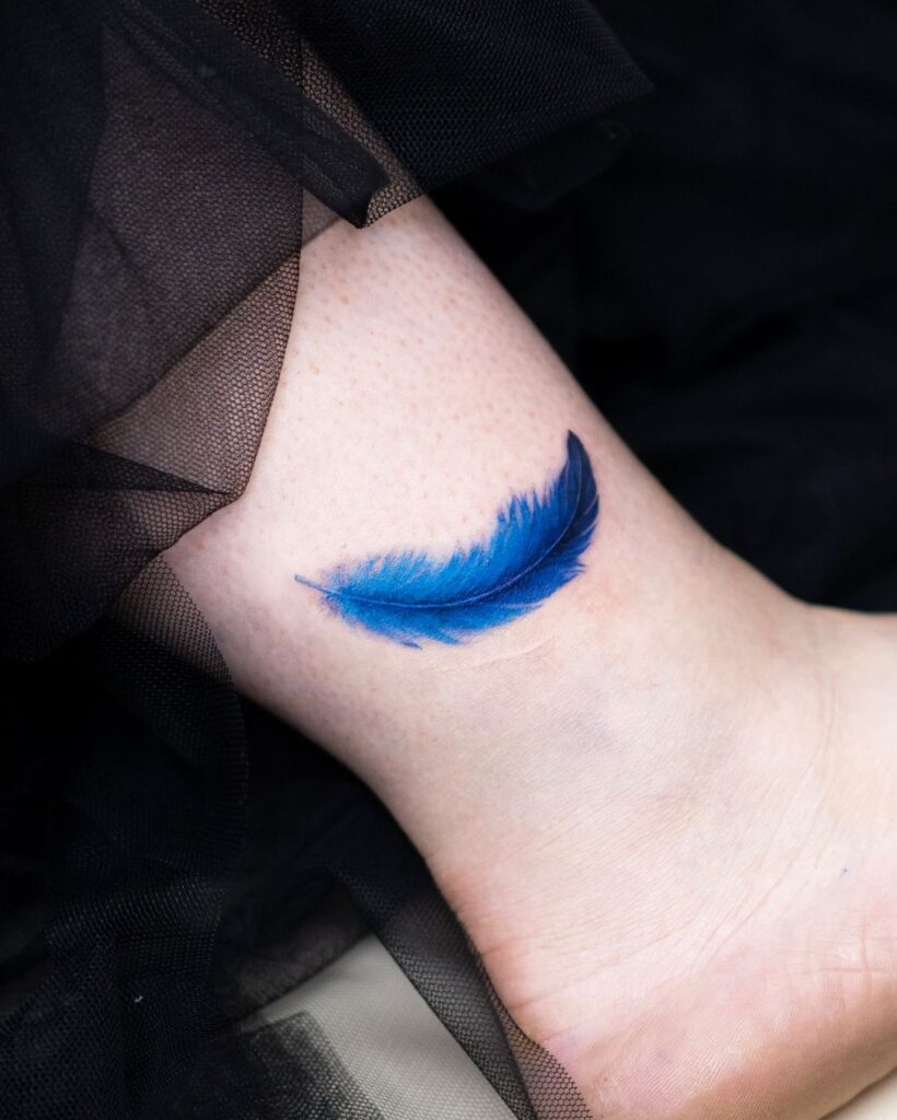 Tatuaggio alla caviglia con piume blu