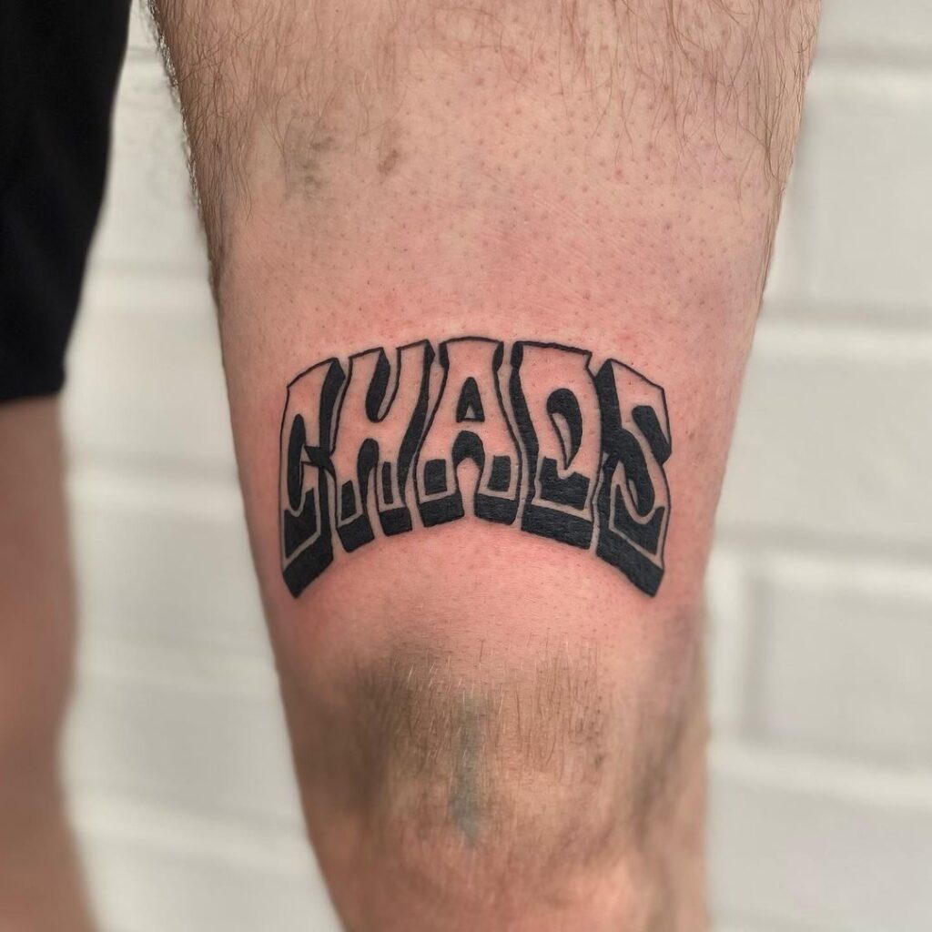 Tatuagem com a palavra Chaos Over The Knee