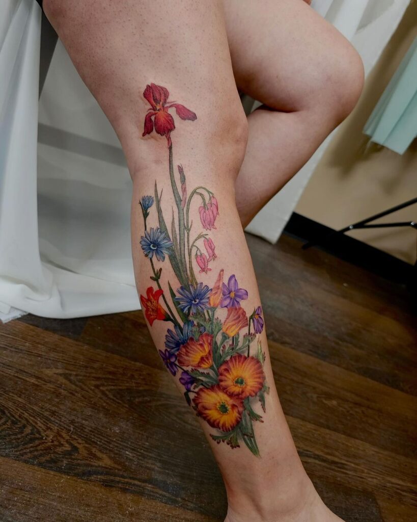 Tatuaje floral de colores en la pierna