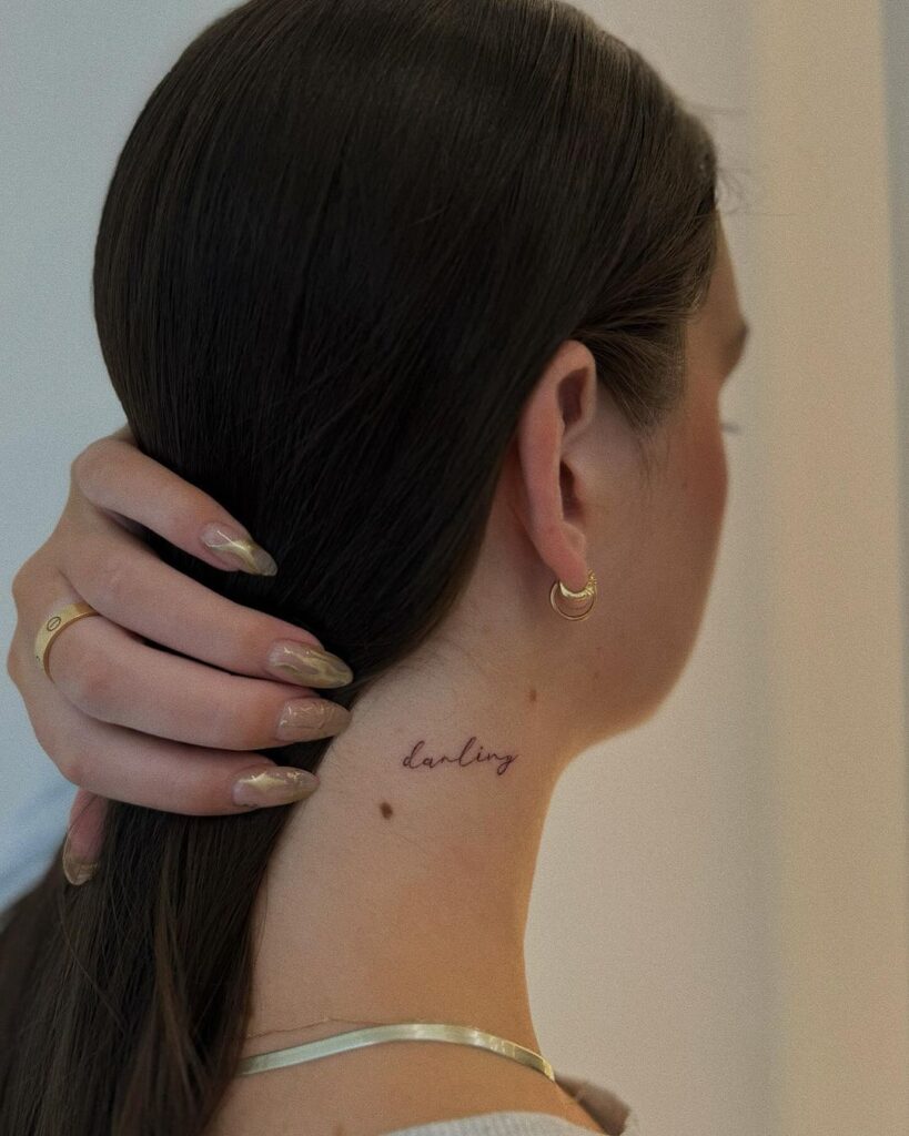 Tatuagem de pescoço com letra cursiva