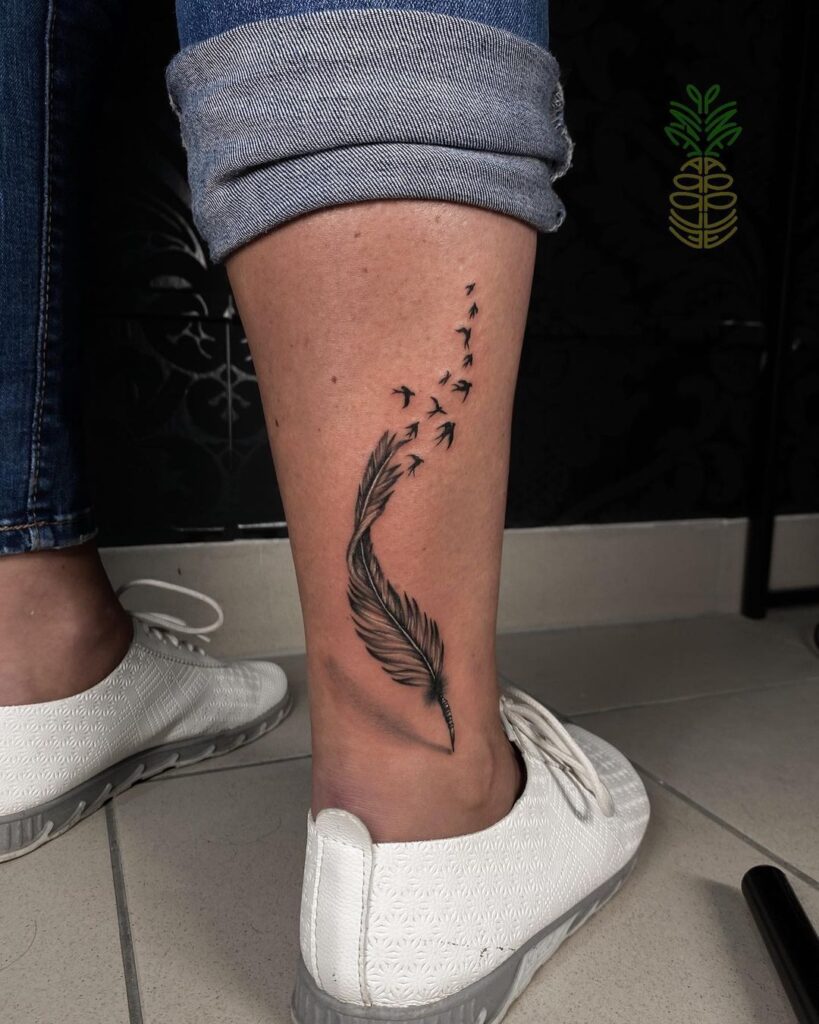 Tatuaje de plumas y pájaros en la pierna