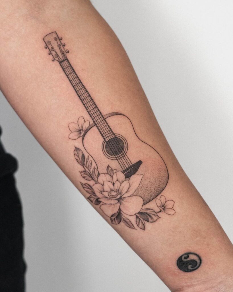 Tatuagem de guitarra e flores