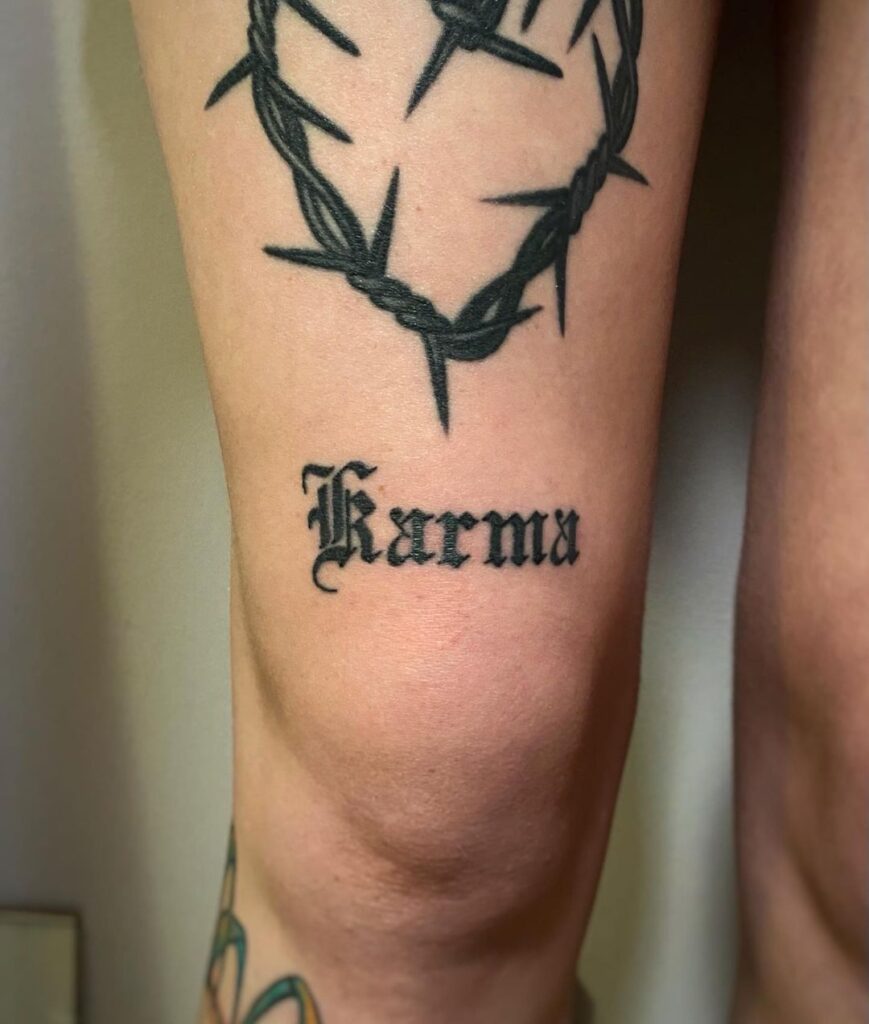 Tatuagem com a palavra Karma Over The Knee