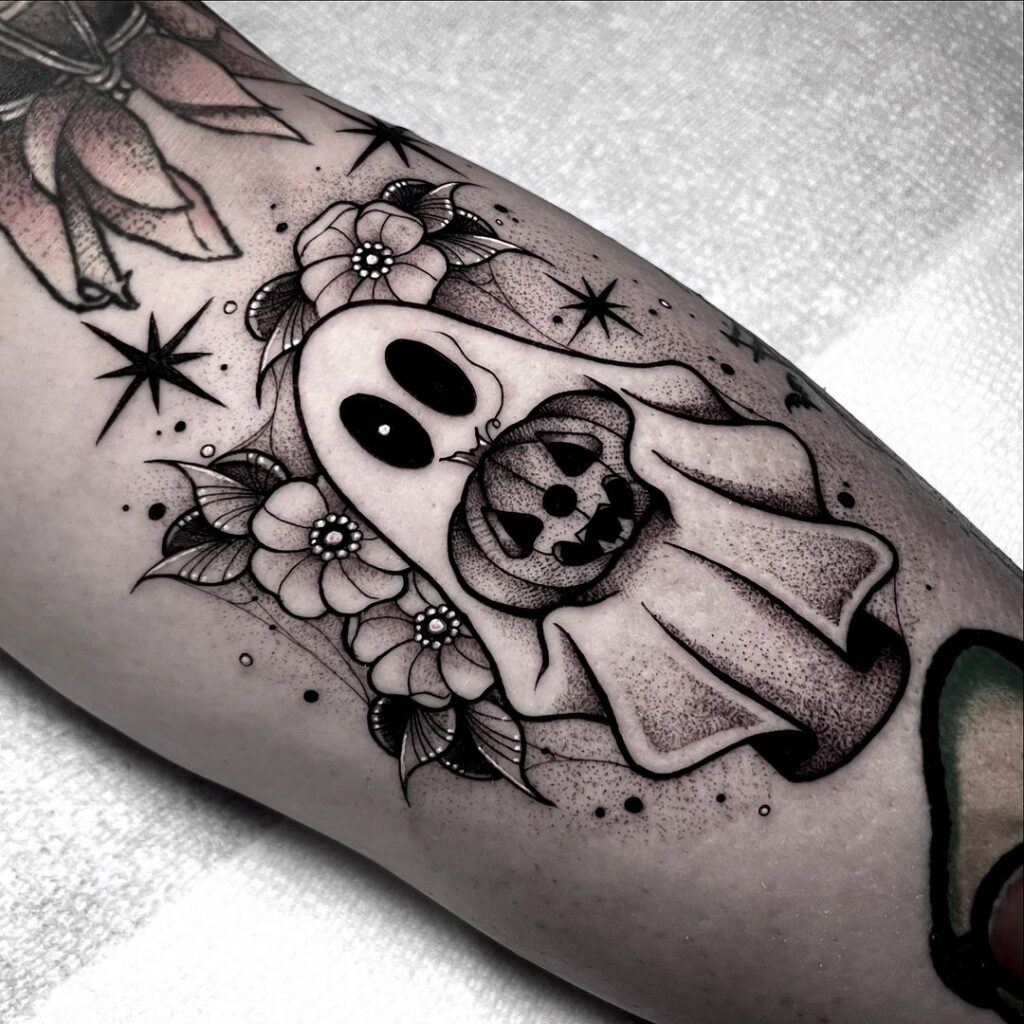 Tatuaje de un mini fantasma con una calabaza en la mano