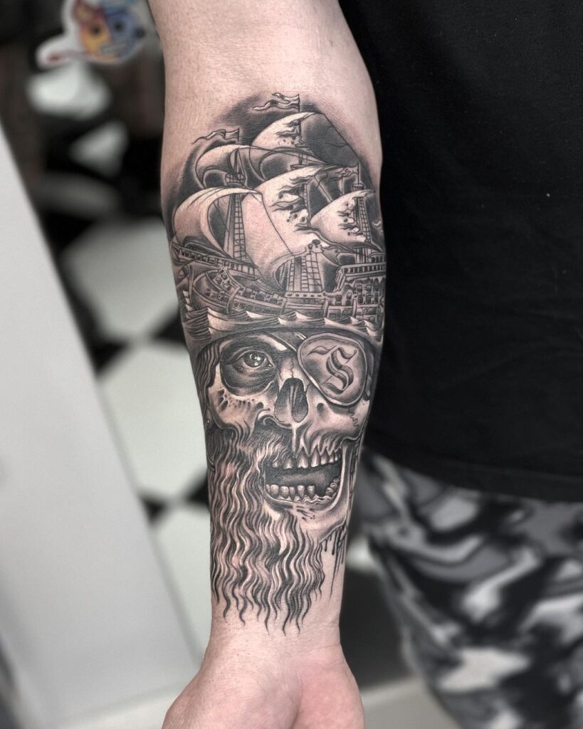 Tatuagem de navio pirata e caveira no antebraço