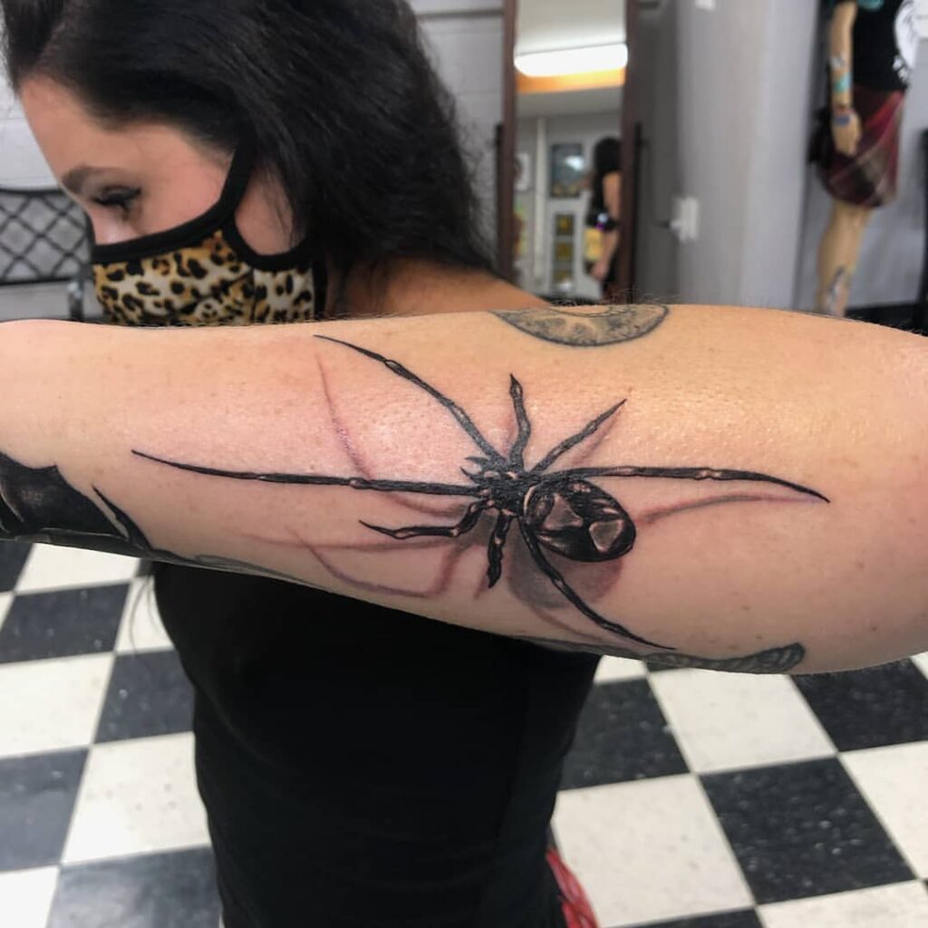 Tatuagem de viúva negra no antebraço lateral