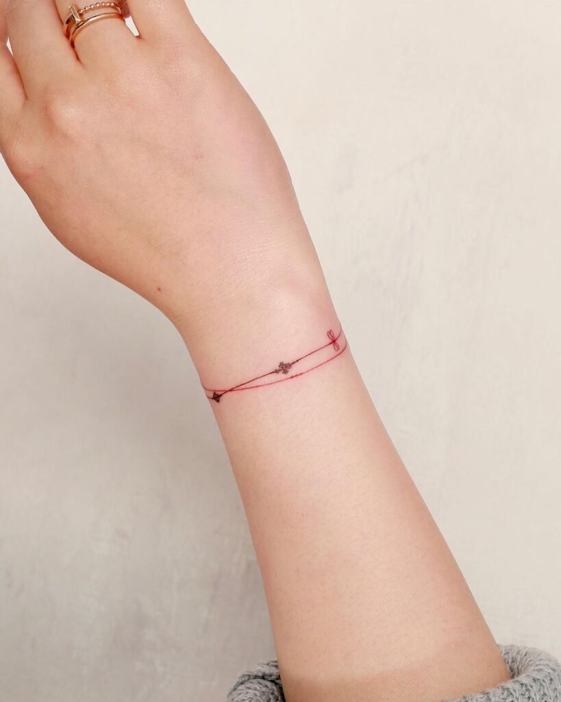 Sutil tatuaje de pulsera roja