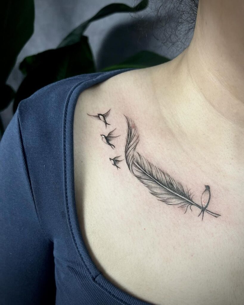 Tatuaje de golondrinas y plumas en la clavícula