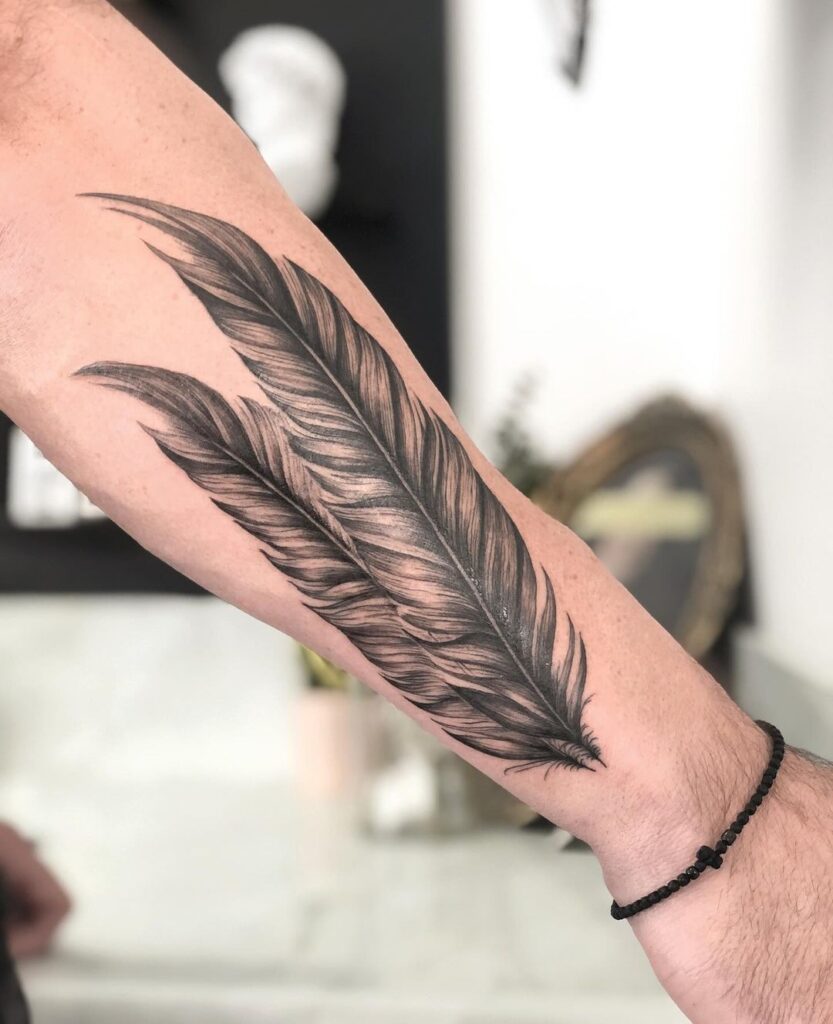 Tatuaje de dos plumas en el antebrazo