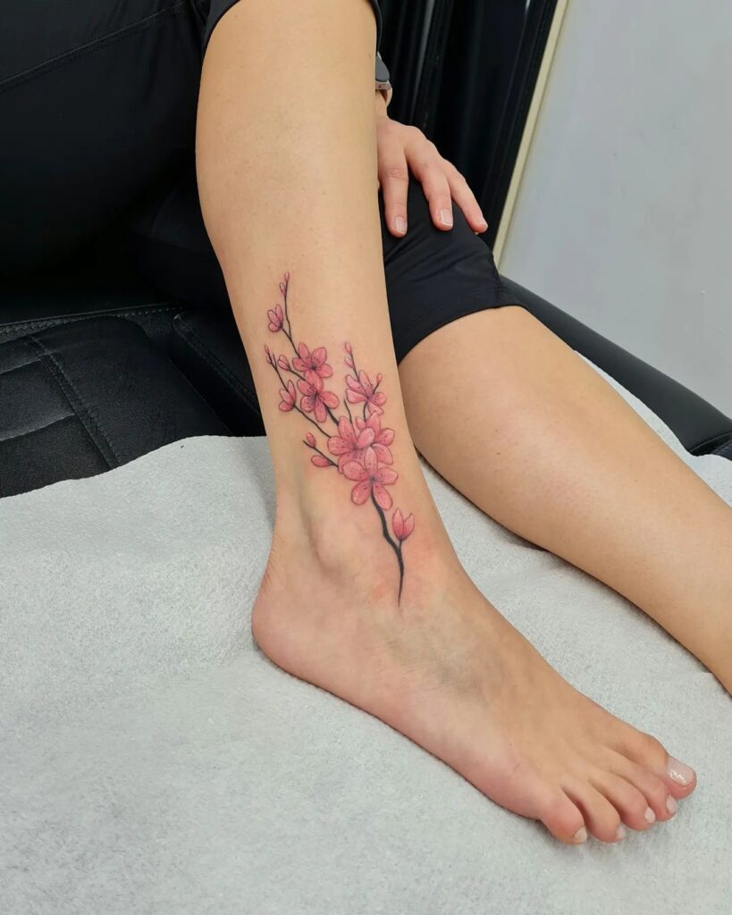 Tatuaje de flor de cerezo en el tobillo