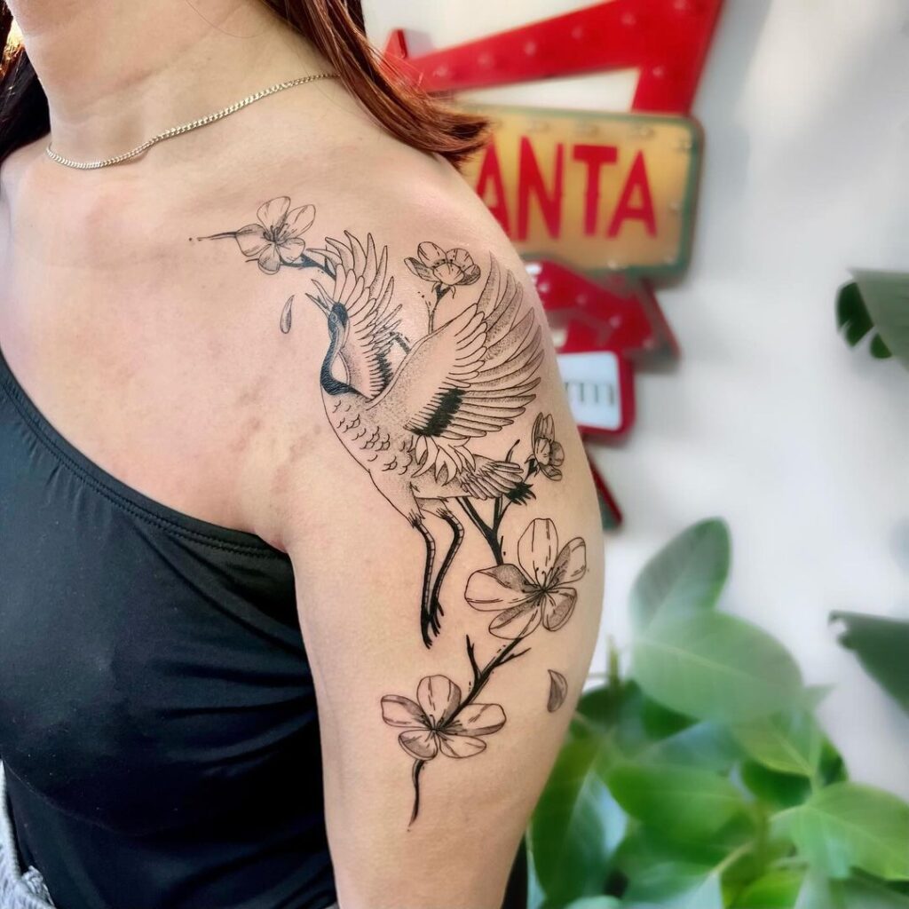 Tatuagem de grou e flor de cerejeira