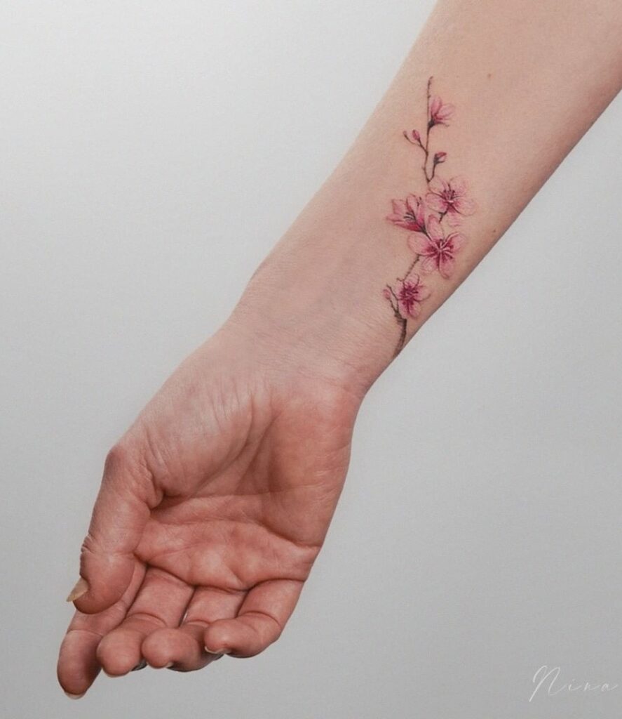 Tatuagem delicada de uma cerejeira em flor