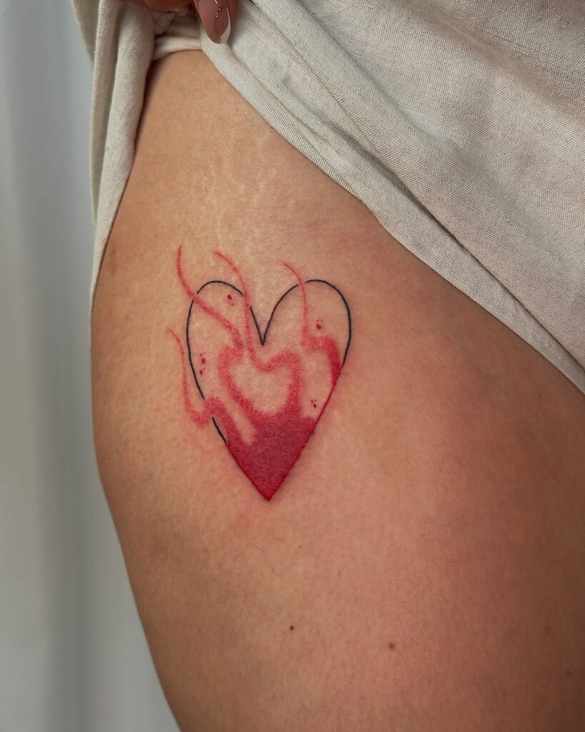 Tatuaje de corazón de fuego en la parte superior del muslo