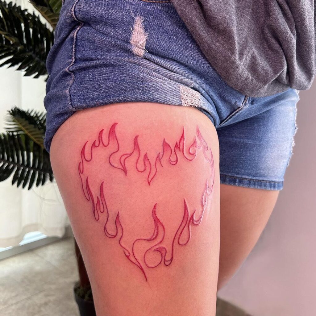 Tatuaje de corazón de fuego en el muslo