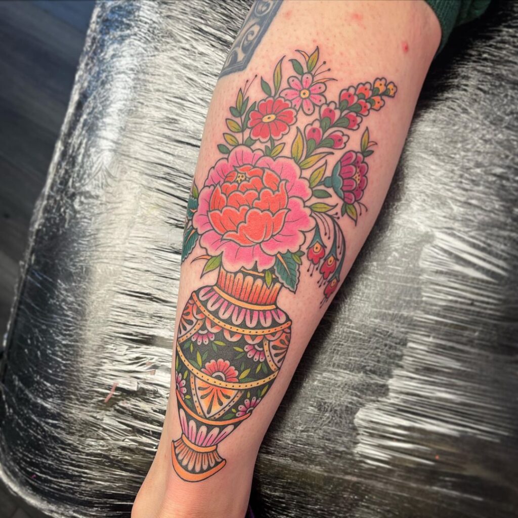 Tatuaje de un jarrón con flores de estilo folclórico