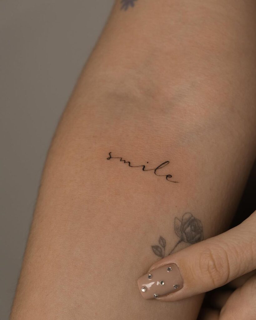 Tatuaggio minimalista con scrittura a linee sottili