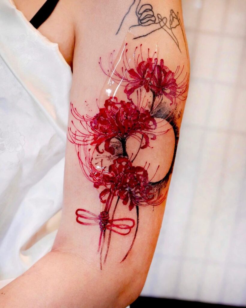 Tatuagem de lírio-aranha vermelho e fio vermelho