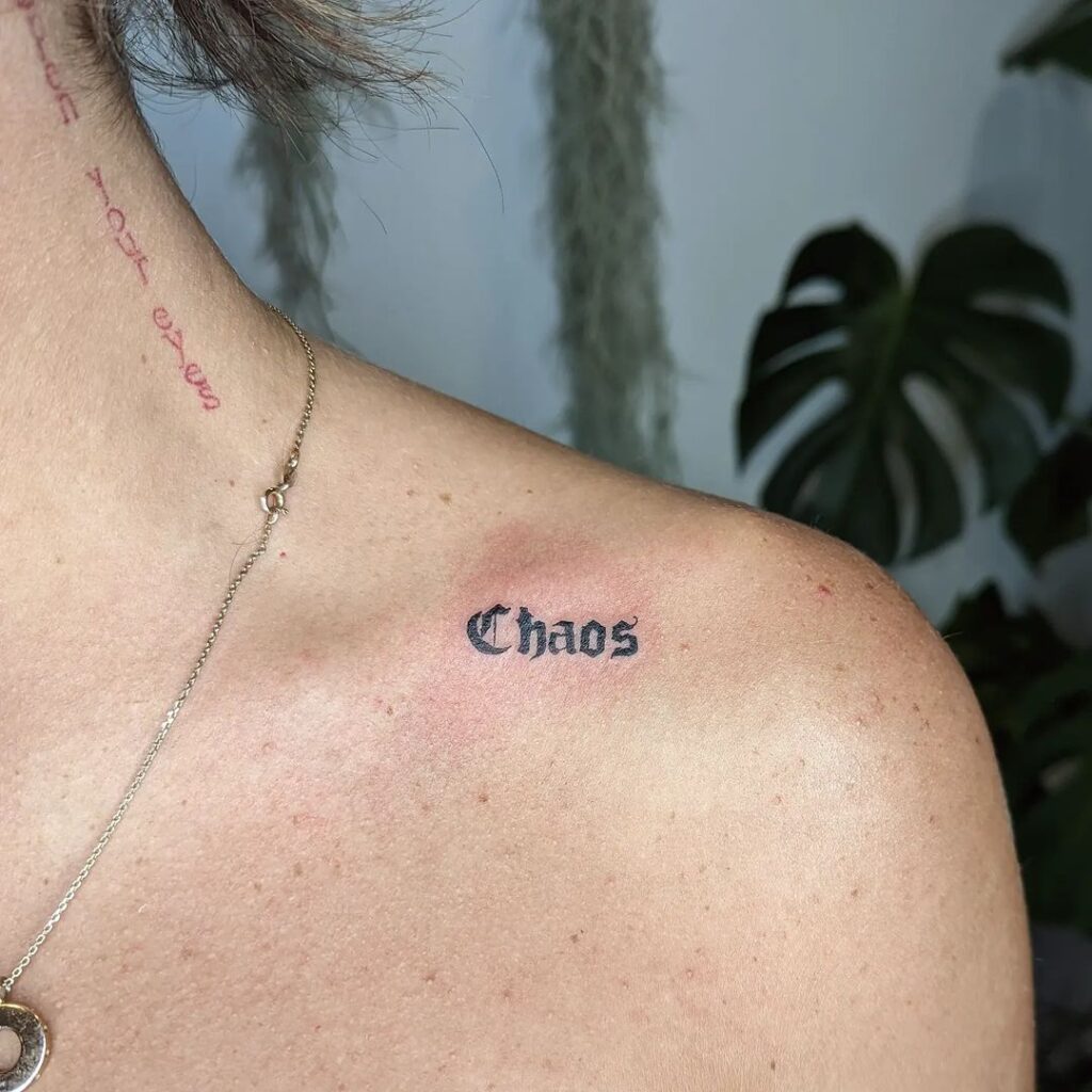 Tatuaggio con scritte Chaos sulla clavicola