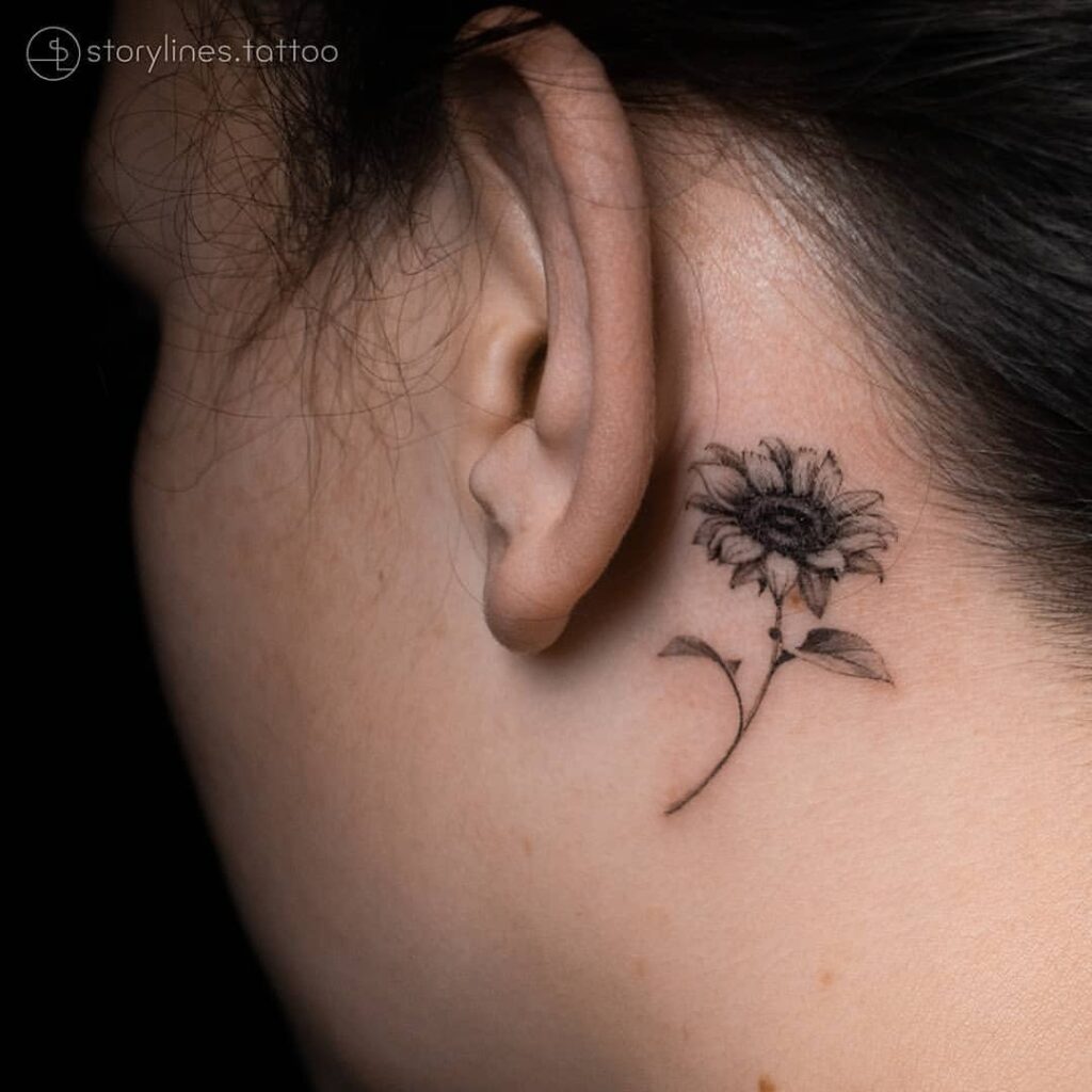 Tatuaje de un girasol detrás de la oreja