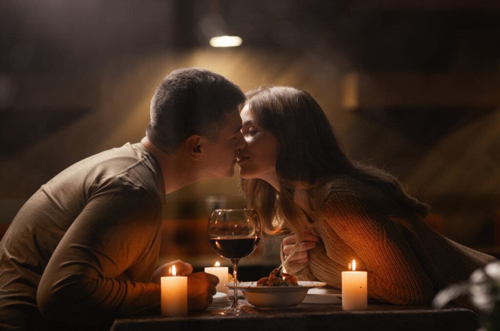 uomo e donna che si baciano durante la cena