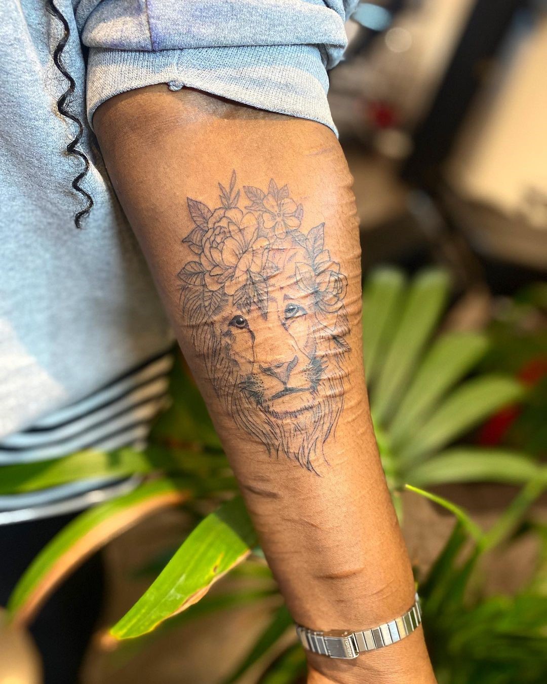 Tatuagem de leão com flores