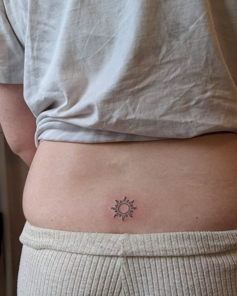 Tatuaje de sol en la parte baja de la espalda