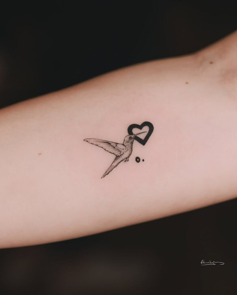 Tatuaggio con micro cuori e colibrì