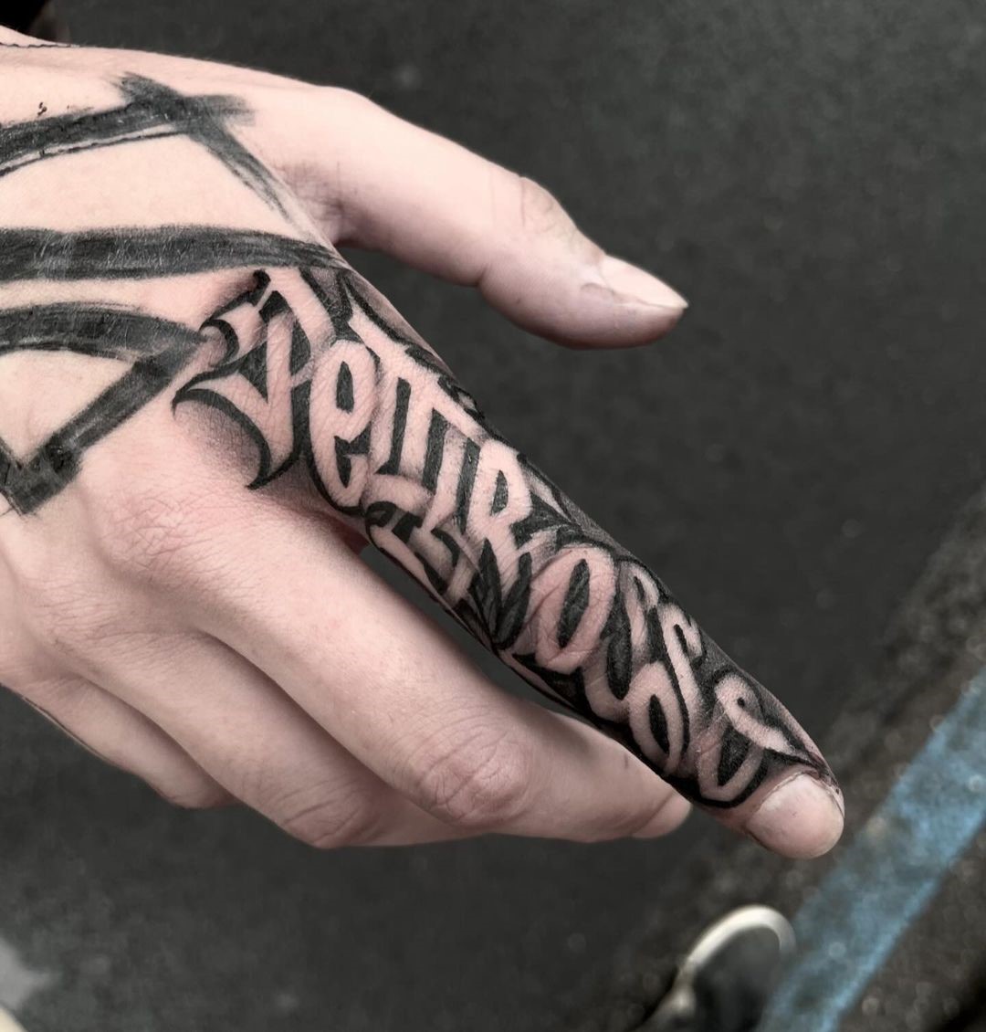 Tatuaggio con una parola e un dito