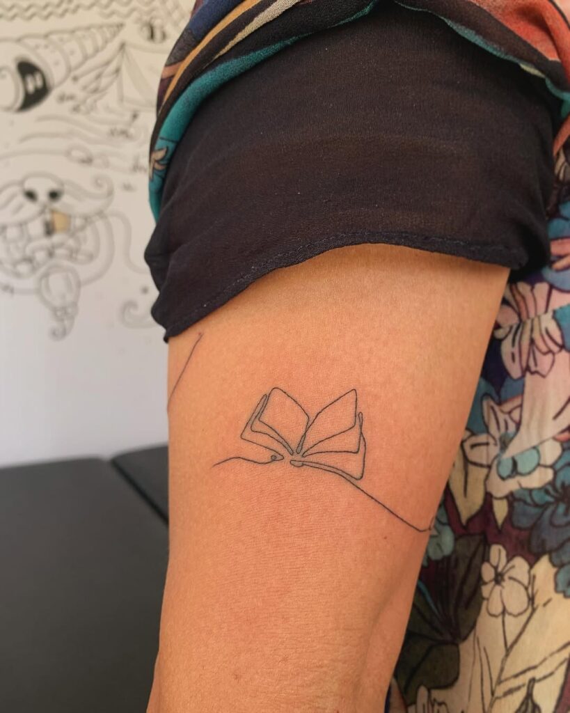 Tatuagem de uma linha em livro aberto