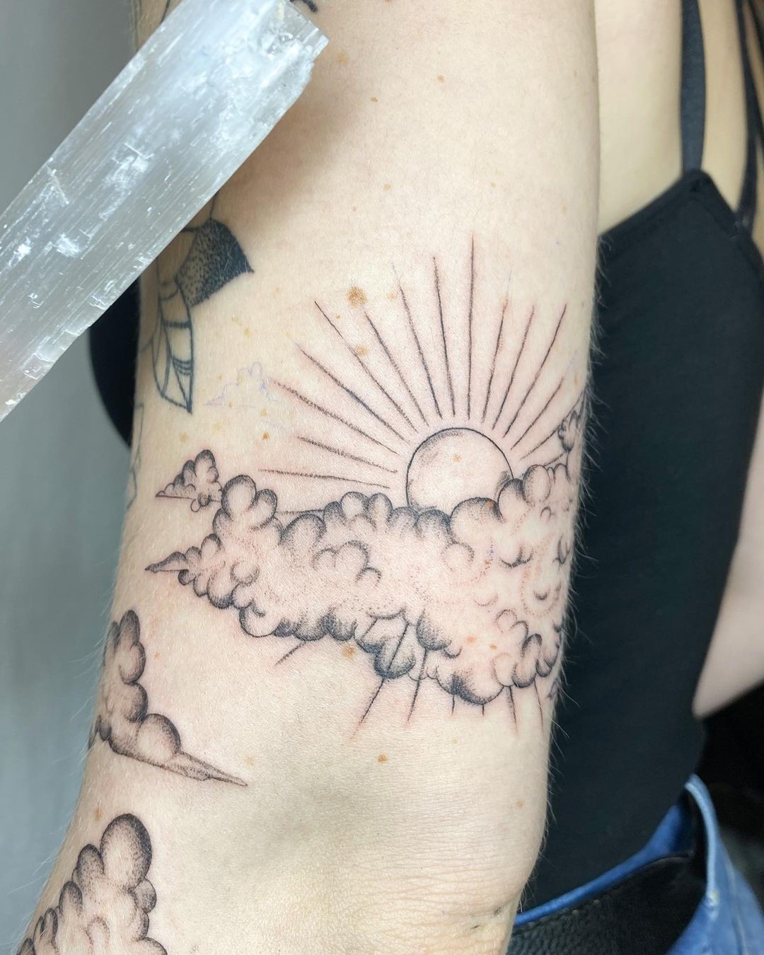 Tatuagem de sol com nuvens