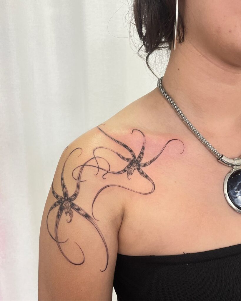 Tatuaggio femminile della spalla con orchidee