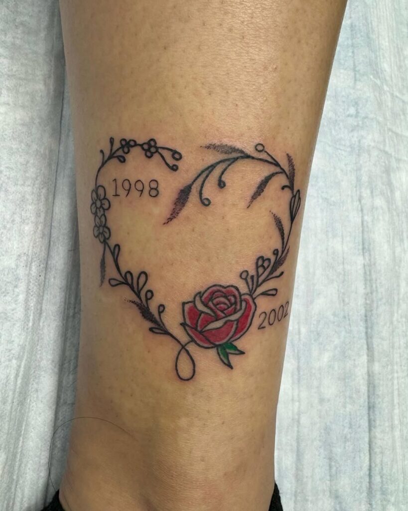 Tatuagem de coração floral com datas de nascimento