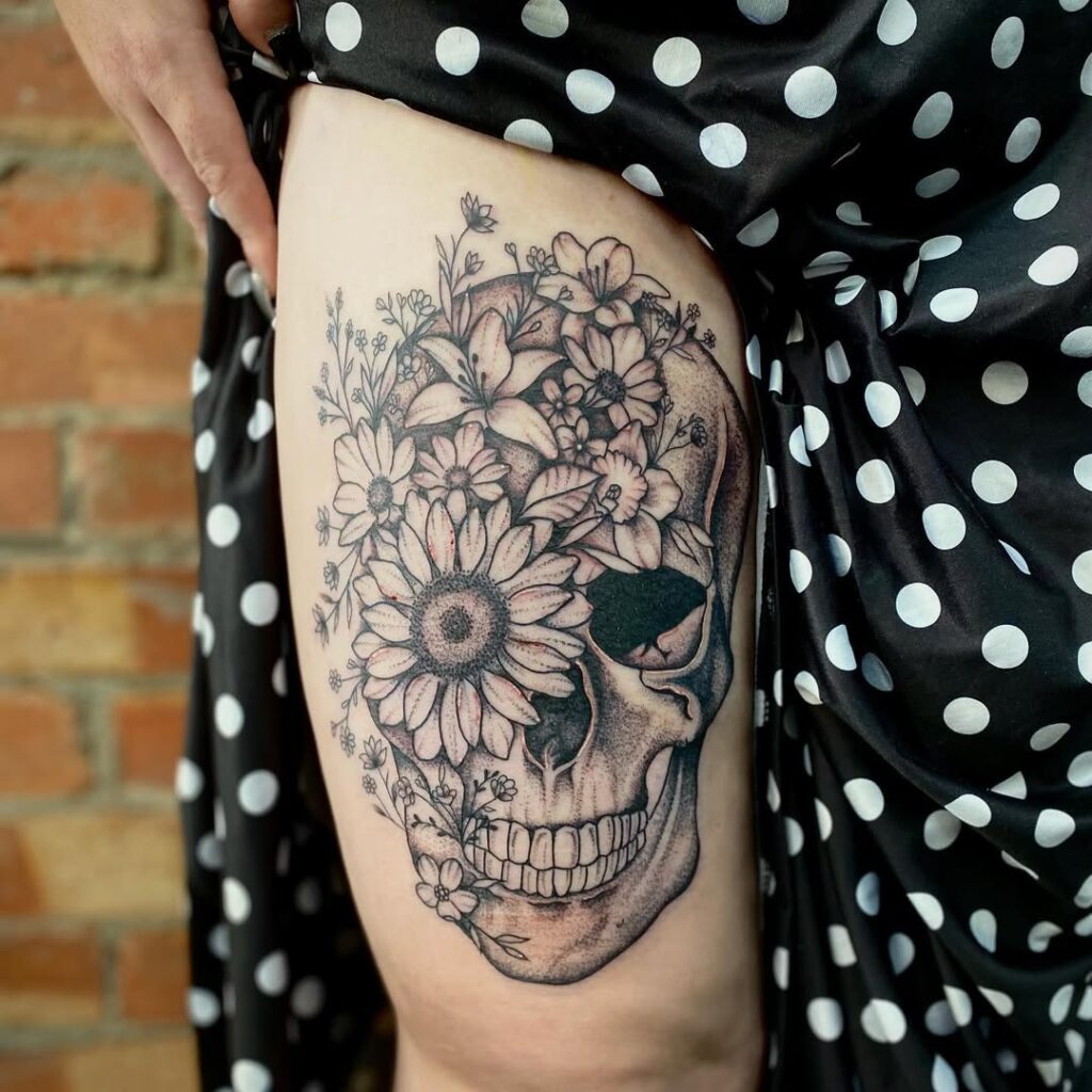 Tatuagem de caveira floral na coxa